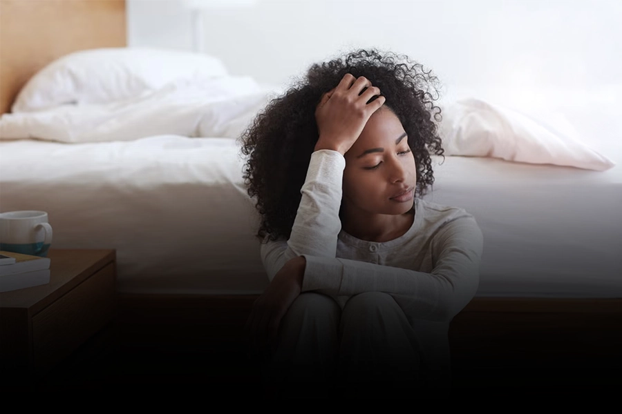 Woman sitting alone showing signs of emotional exhaustion and chronic stress
