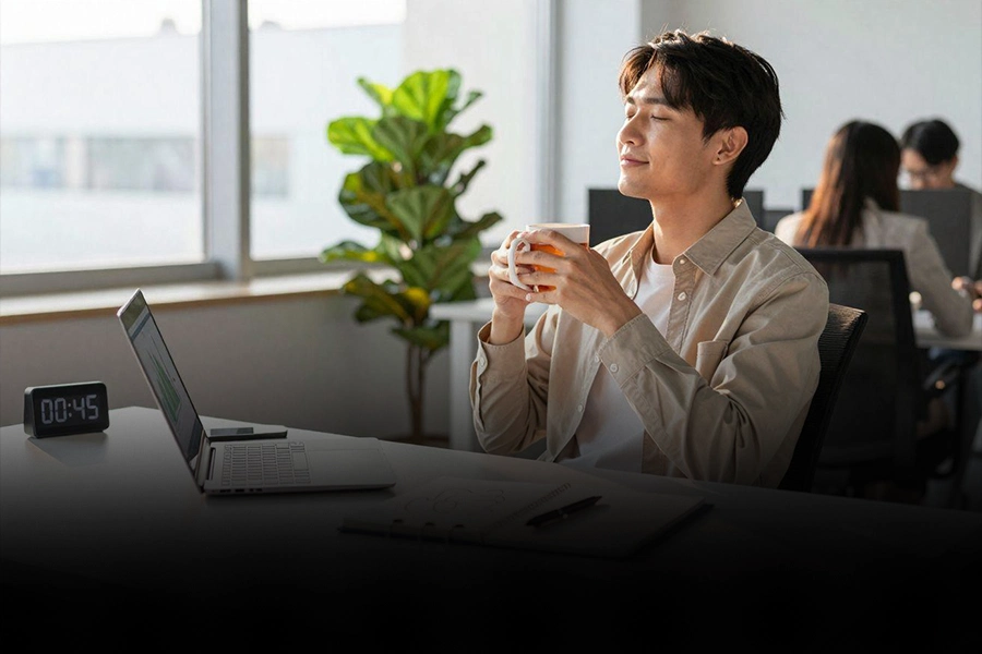 Office worker taking a short break with a cup of coffee to restore focus during work